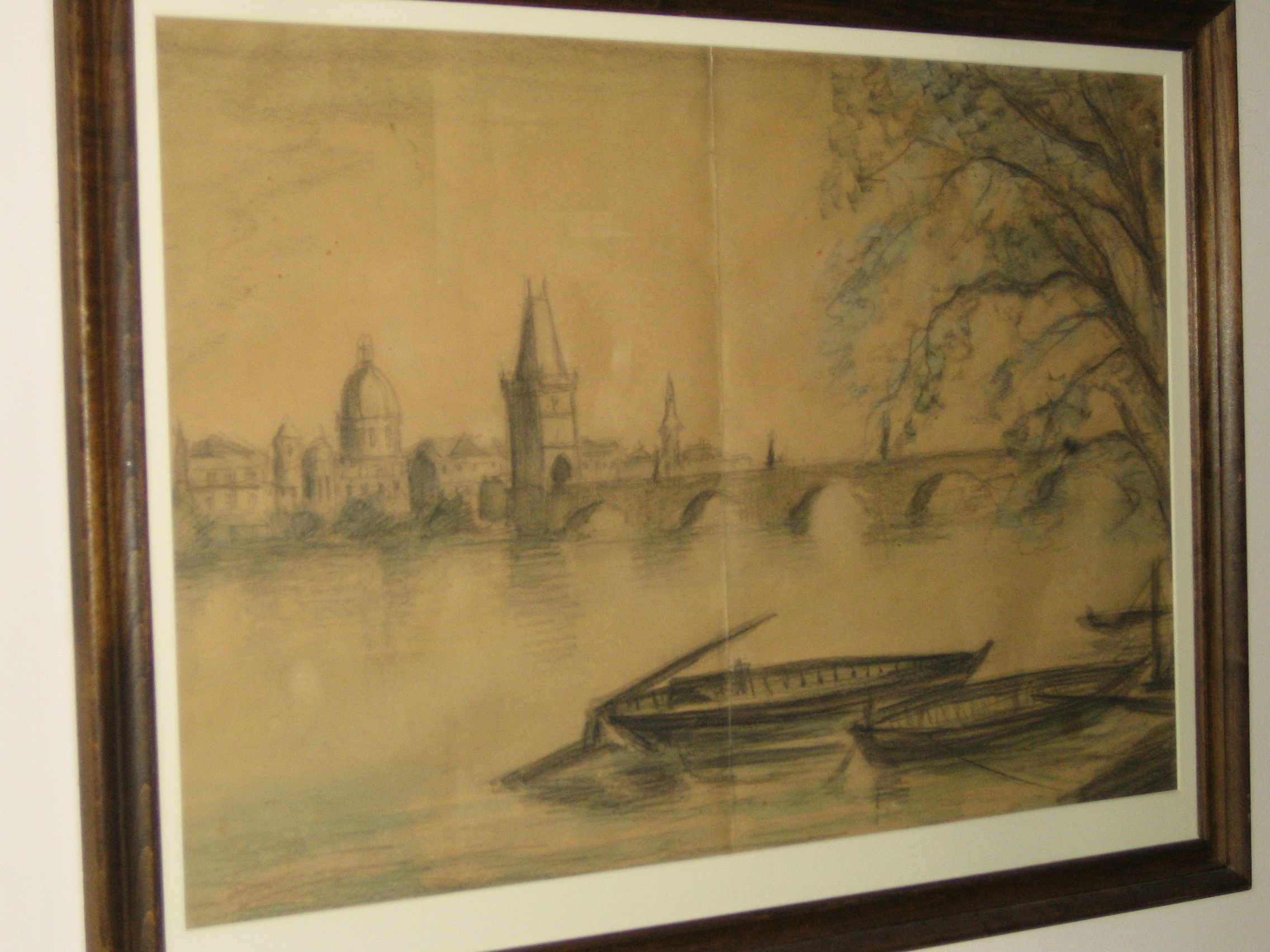 Framed drawing of a landscape of a river with a bridge, canoes and distant buildings 
